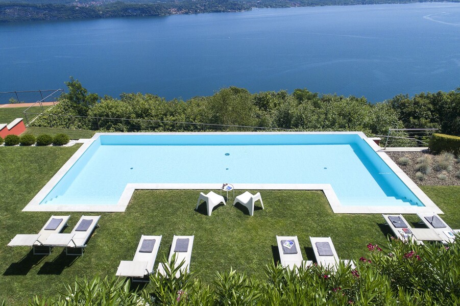 Pool mit Sonnenliegen der Villa Falcone mit Blick auf den Lago Maggiore