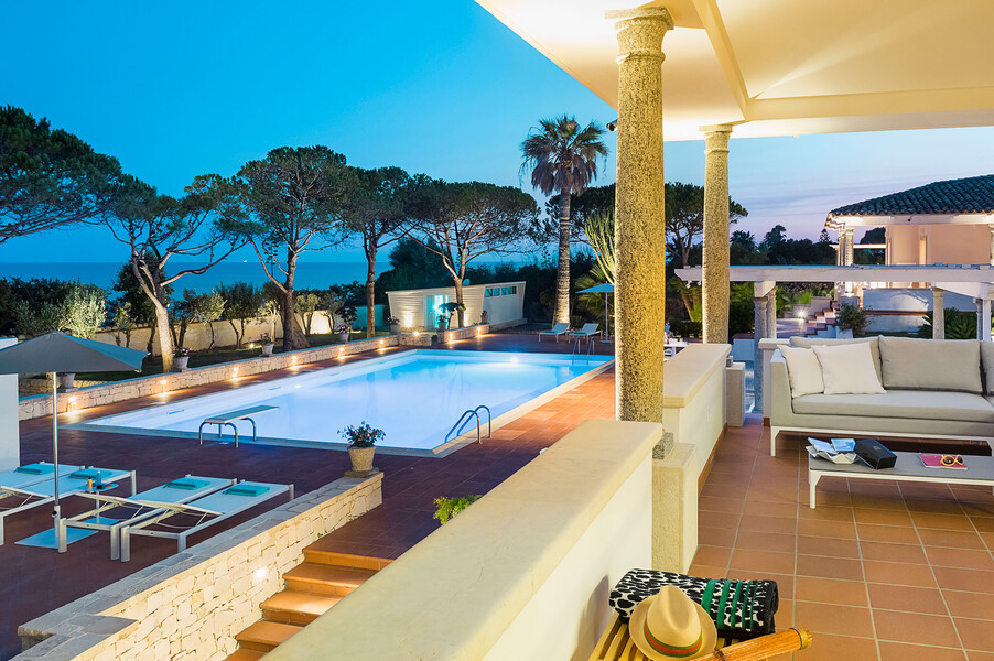 Pool der Villa Maya mit Abendbeleuchtung direkt am Meer in Sizilien