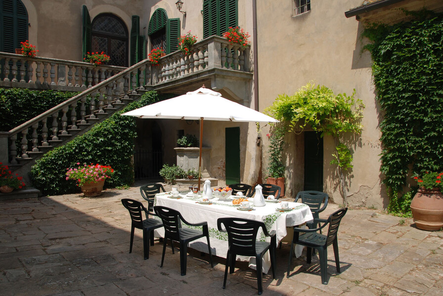 Esstisch im Innenhof der Villa di montelopio bei Pisa in der Toskana