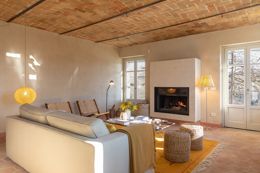 Wohnzimmer mit offenem Kamin in der Villa Casa Moscata Piemont