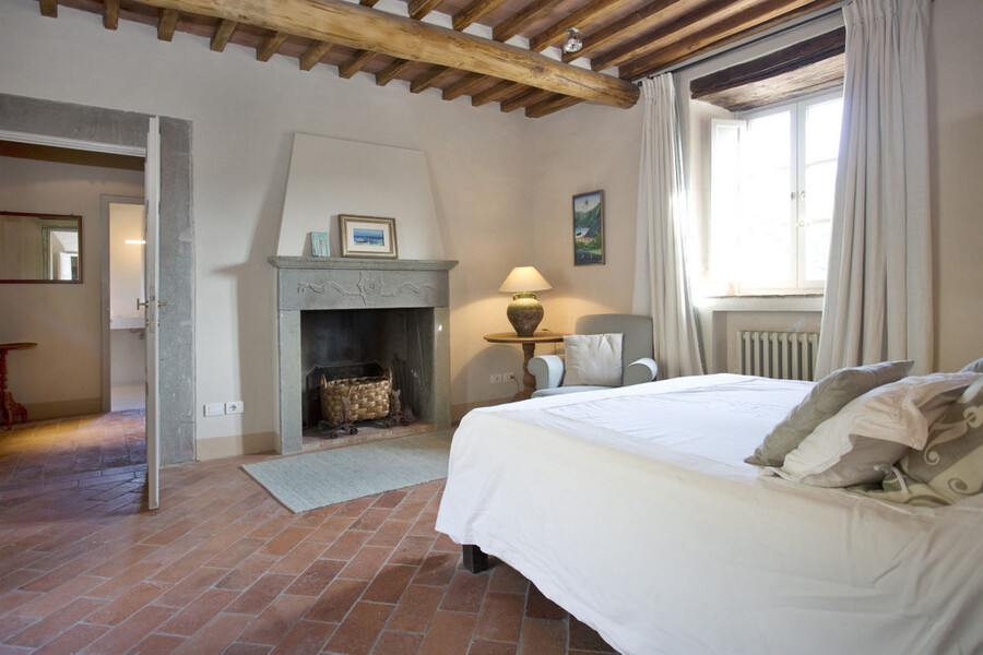 Elegantes Schlafzimmer mit offenem Kamin im Ferienhaus in Lucca