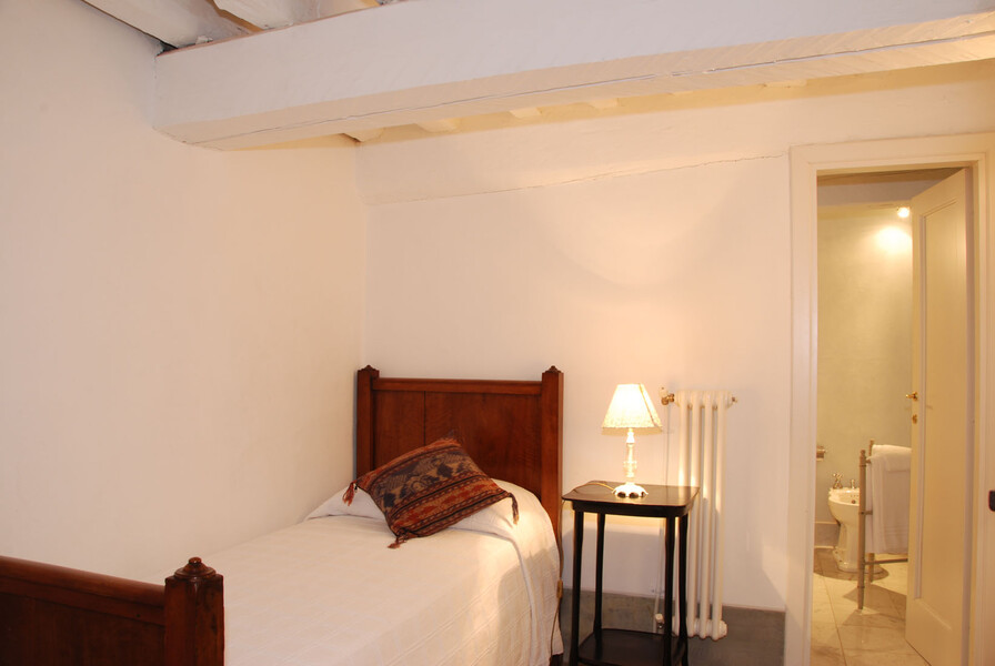 Das Einzelbettzimmer der Ferienwohnung verfügt über ein schmales Bett und ein eigenes Bad