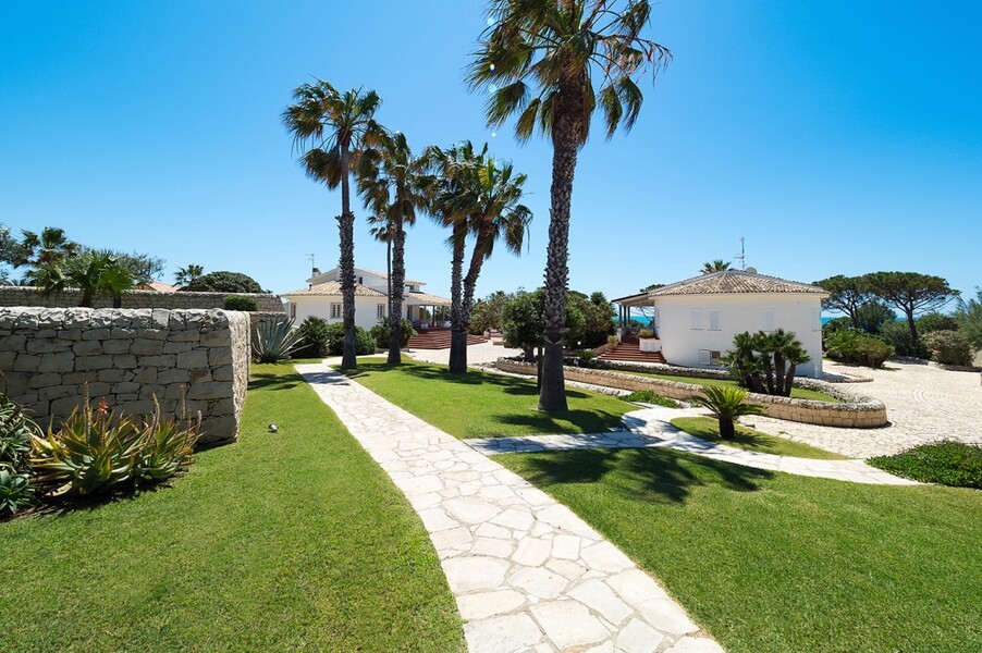 Garten mit Rasen und Palmen der Villa Maya am Meer auf Sizilien