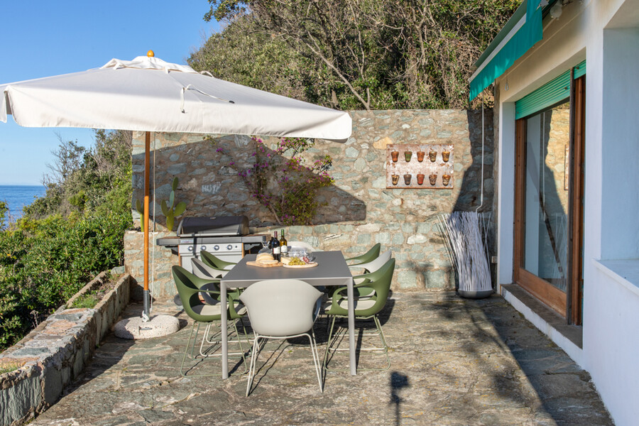 Terrasse mit Esstisch und Sonnenschirm in der Villa Procchio auf Elba