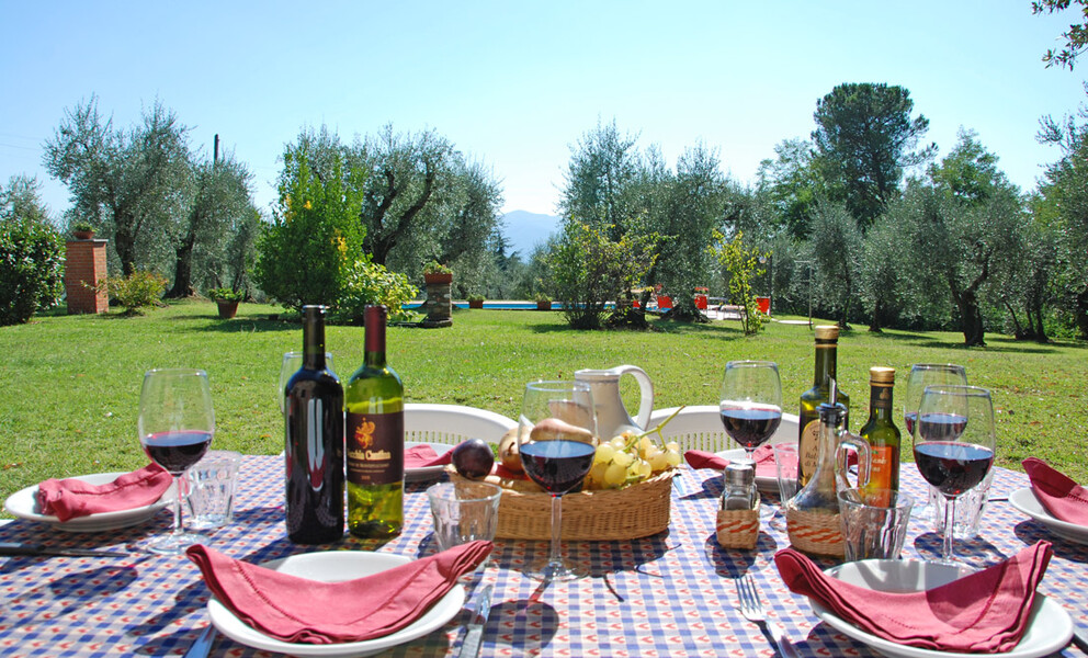 Gedeckter Tisch mit Wein aus Lucca im Garten des Ferienhaus Casa Tonio bei Lucca