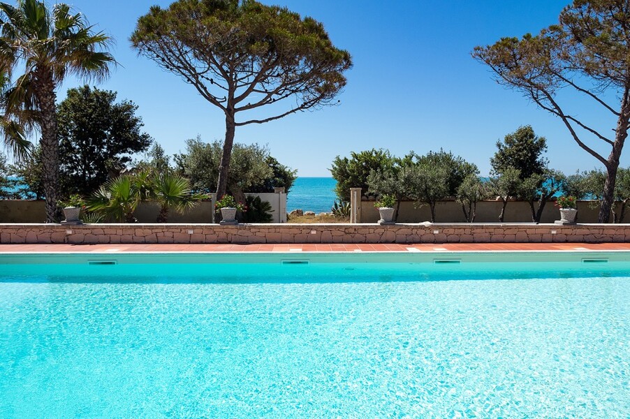 Pool mit Pinien und das Meer im Hintergrund der Villa Maya auf Sizilien