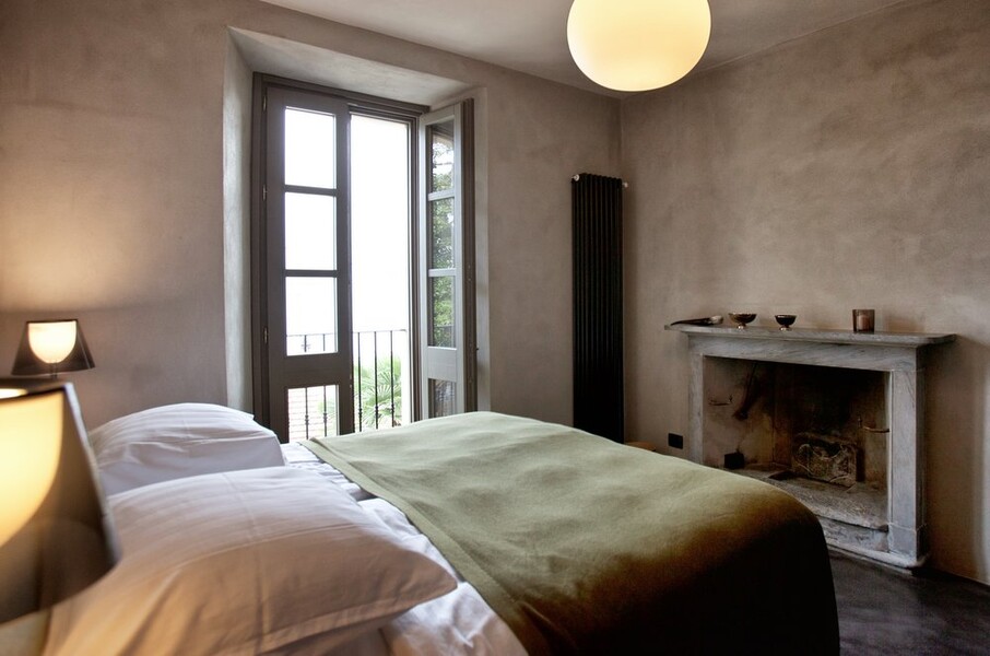 Elegantes Schlafzimmer mit offenem Kamin in der Villa Crotto am Comersee